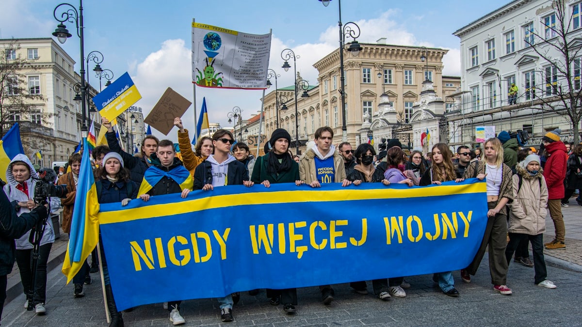 a group of people holding a blue and yellow banner